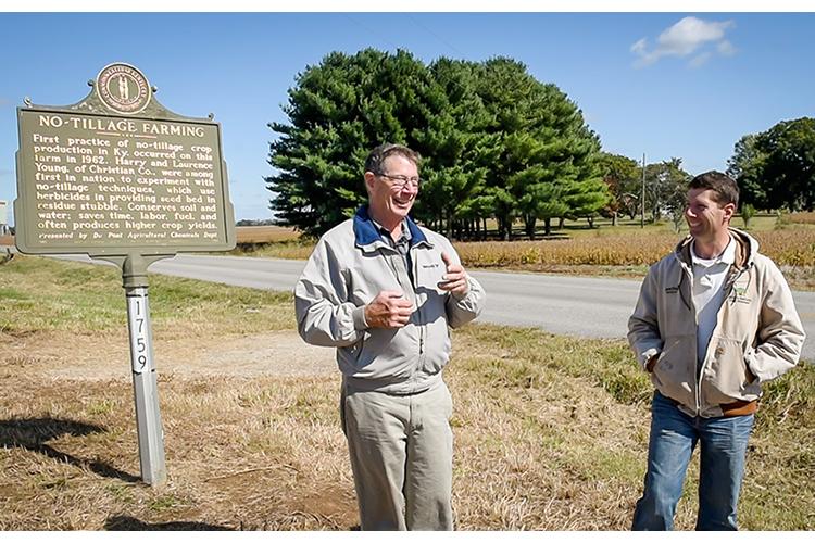 Christian County farmers John and Alexander Young stand in front of the historical marker on their Herndon farm where the late Harry Young planted his first commercial crop of no-till corn. Photo courtesy of No-Till Farmer. 