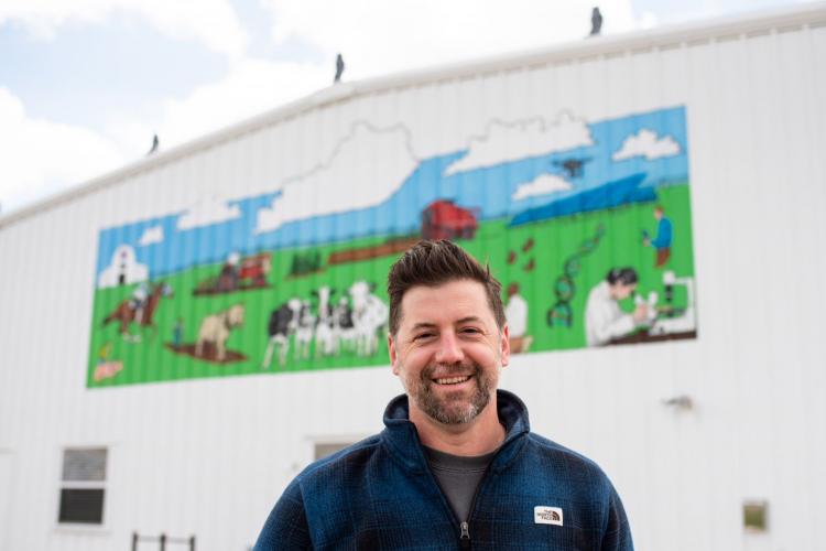 Josh Mitcham stands in front of his mural on UK's North Farm.