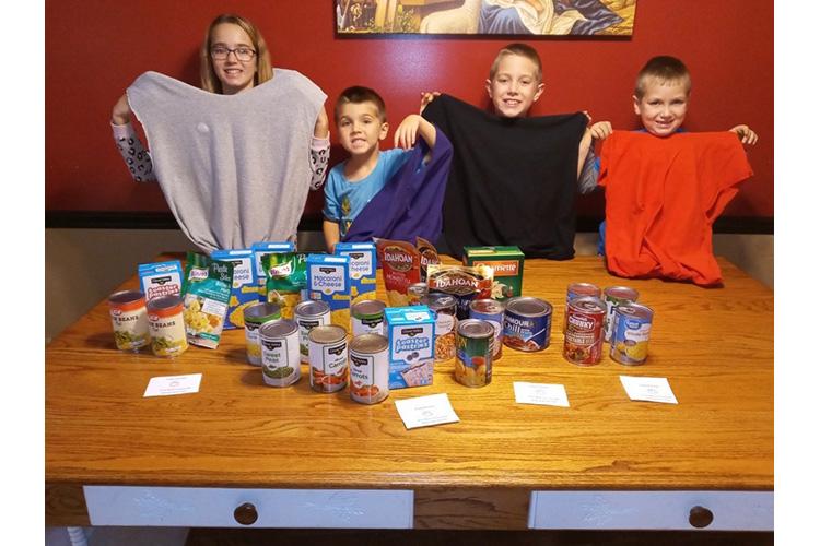 Nelson County 4-H'ers and siblings Brooklyn, Trenton, Colton and Easton Hunt display the upcycled T-shirts they made and the food they collected to put in them as part of the Nelson County 4-H Helping Hands Club. Photo by Shawna Hunt.
