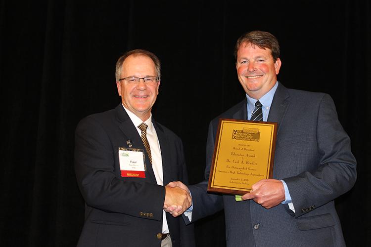MACA president Paul Edsten presents UK's Carl Bradley with the association's Educator of the Year Award at its annual conference in Indianapolis. Photo provided by MACA.