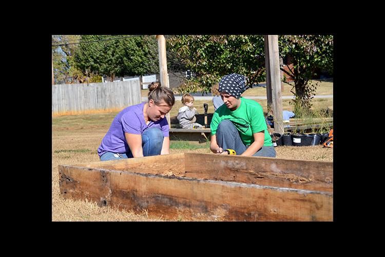 Corina Common and Jennifer Walker construct raised beds at the community garden in Metcalfe County. 