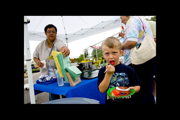 Aaron Begley, 4, tries some cinnamon apples at the Cooperative Extension booth at the Boone County Farmers Market. 