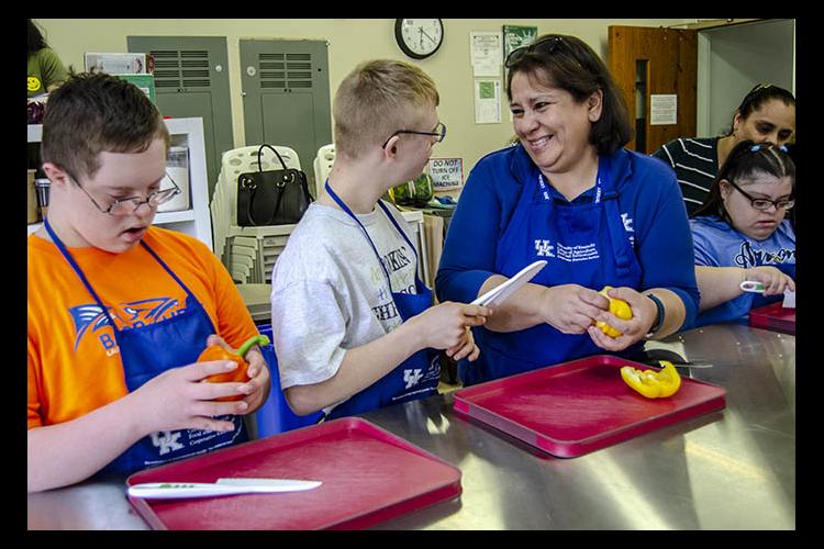 (l-r) Ethan Bourne, Sam Elbert, Jacqui Denegri, Maria Rosales, with her mother Francisca Rosales. Denegri shows participants in Fayette County Extension’s Teen Cuisine class how to chop bell peppers. 