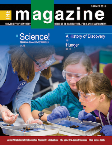 Cover of the AgMagazine for Summer 2015. Cover photo displays a teacher working with two children to dissect an insect.