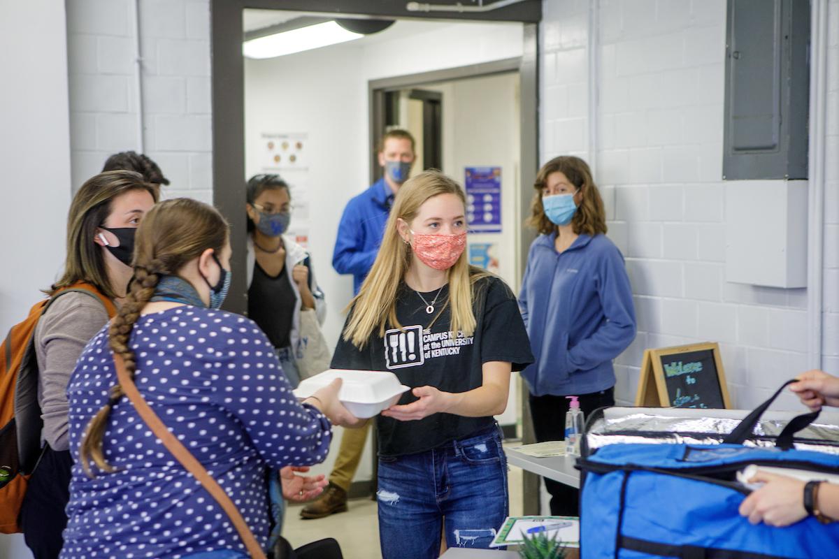 Jordan Hinton, co-chair of Farm-to-Fork and a junior dietetics major, serves boxed lunches to UK students. Farm-to-Fork provides a free nutritious meal to UK students each week, regardless of their financial situation. 