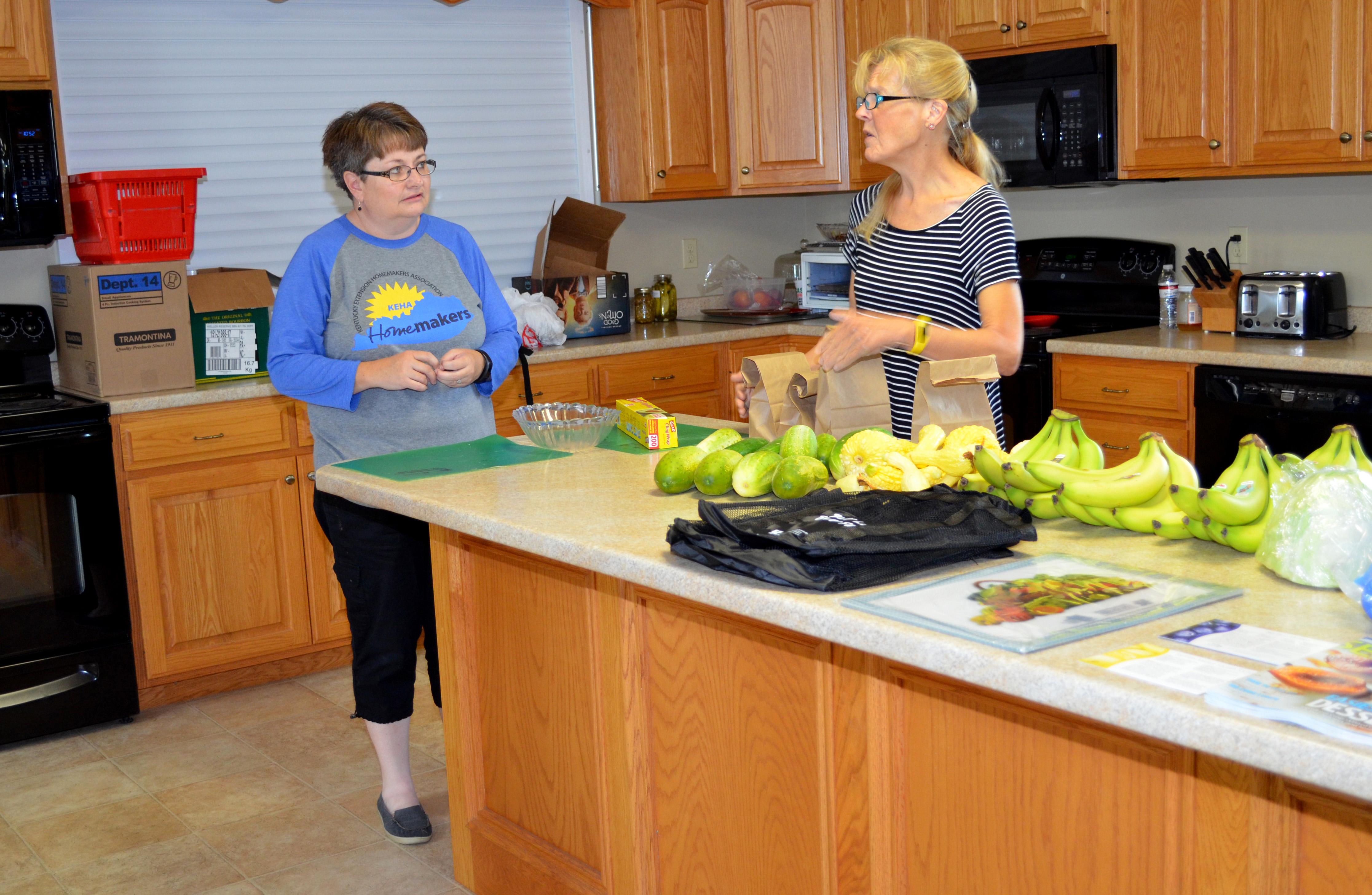 Debbie Messenger, left, Cumberland County family and consumer sciences extension agent, and Extension Homemaker Cathy Slowik sort  fresh produce for recipients of their summer feeding program. Photo by Katie Pratt, UK agricultural communications.