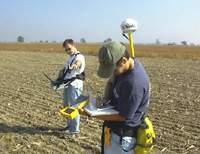 Matt Bethel, research project manager with ITD-Spectral Visions, and Adam Smith, a member of NASA's ground reference information team, take bare-soil radiometer reflective readings.