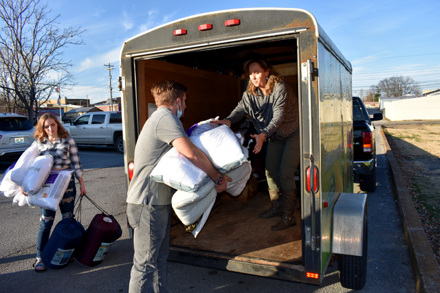 Todd County 4-H'er Andrew McDonald hands bedding supplies to Lee Ann McCuiston, Todd County 4-H youth development agent, who was loading a trailer of supplies to take the West Kentucky 4-H Camp in Dawson Springs. 